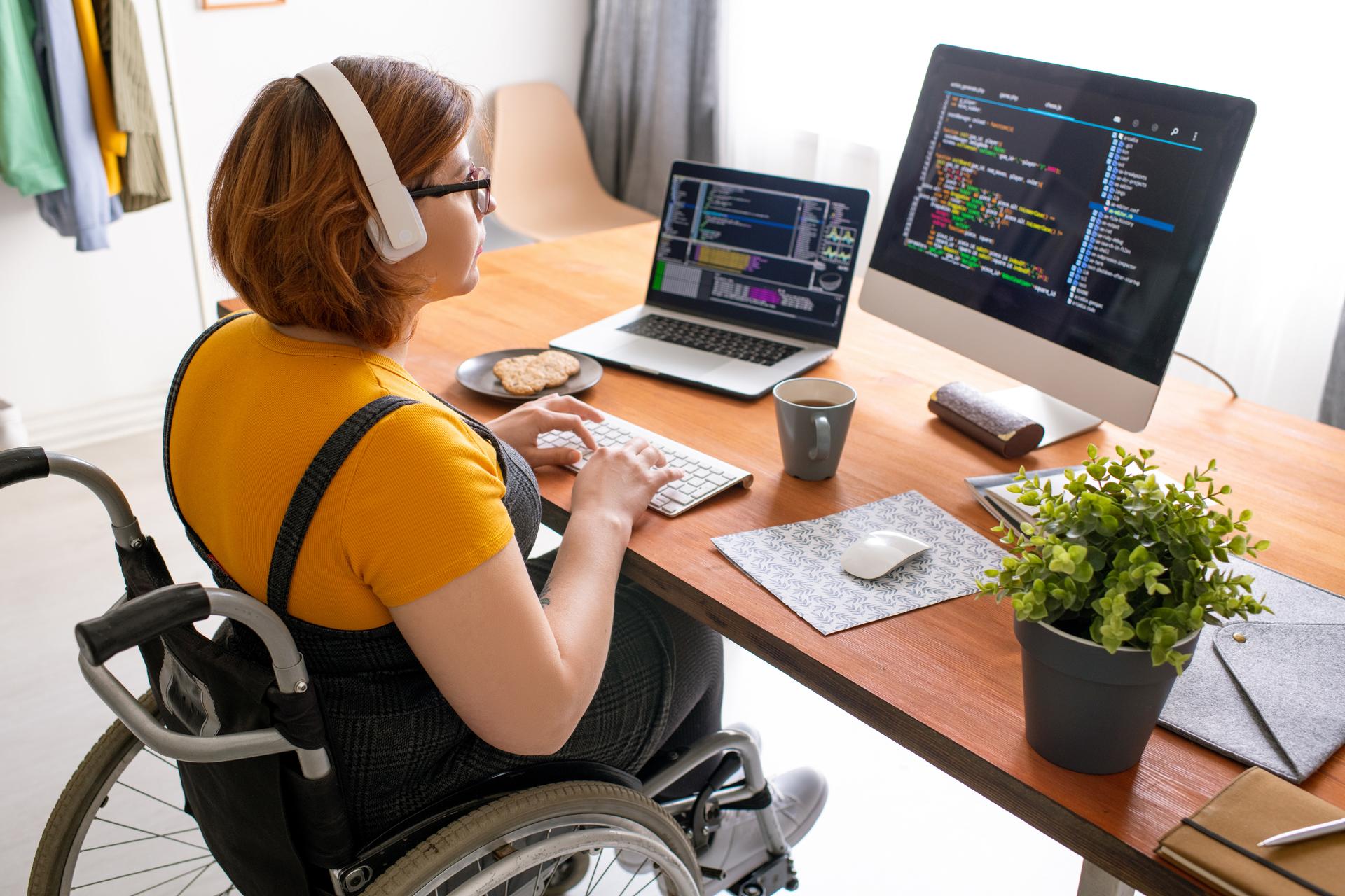 Student in a wheelchair sat at her desk working on a computer