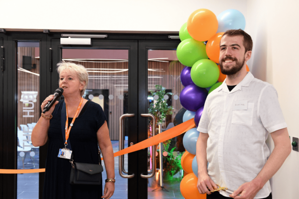 Sally Alexander, CEO of Milton Keynes College Group, and former SCIoT student Jacob Vale, stood in front of colourful balloons and an orange ribbon at the opening of the new South Central Institute of Technology building in Bletchley.