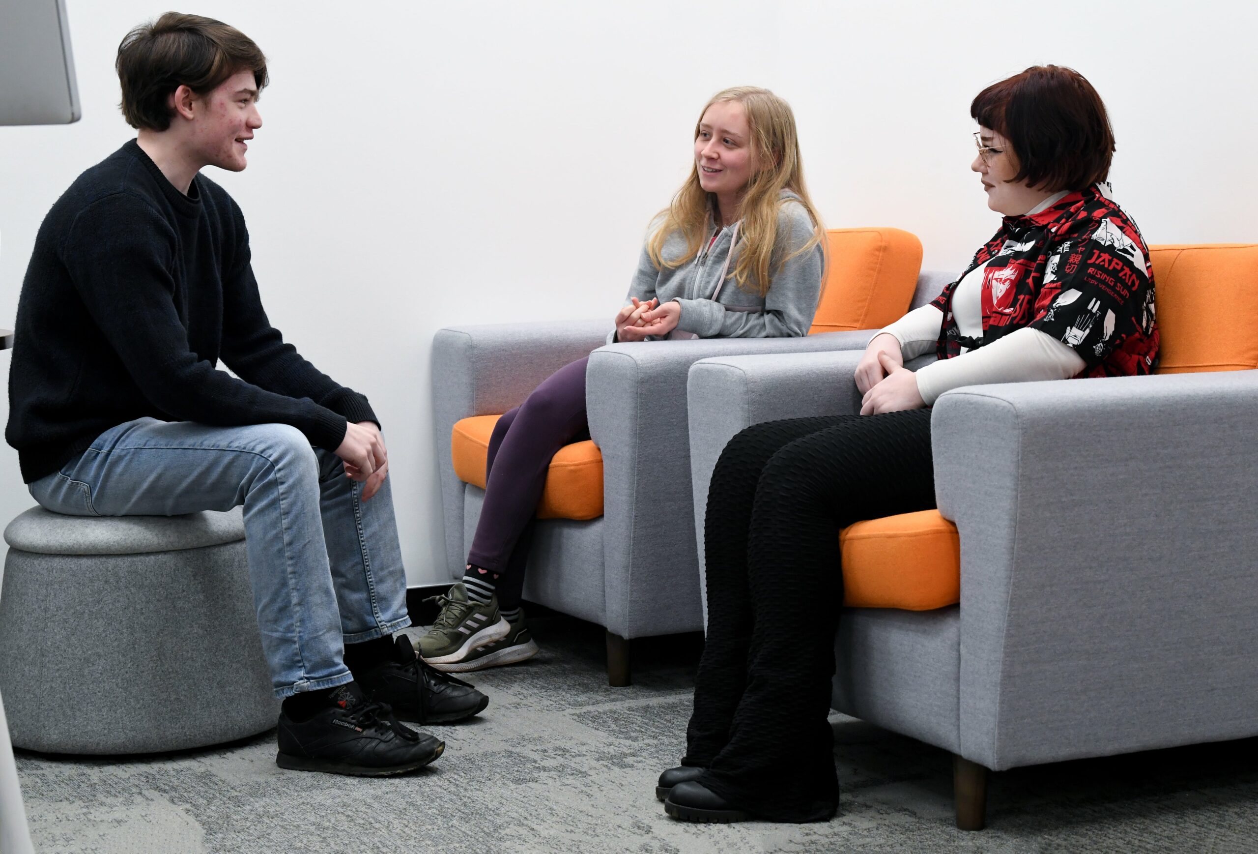 3 students talking together in a communal space