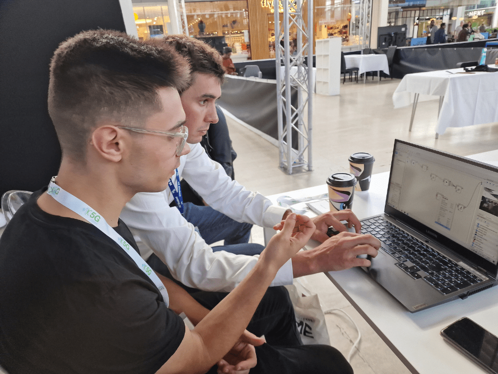 Students working together on a laptop to program Robots.