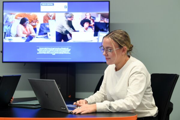 Female student working on a laptop in a SCIoT classroom